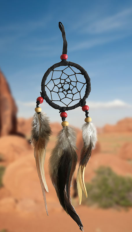 small black dreamcatchers with red and tan beads and brown feathers on western background